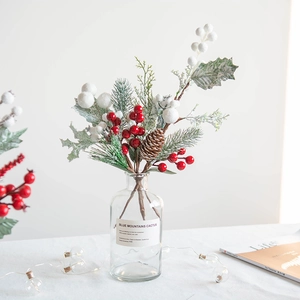 Christmas red berry and pine cone floral arrangement in glass vase for home festive decor