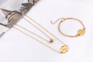 Detail of gold double-layer necklace and bracelet set with infinity symbols on white
