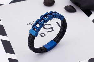 Détail de la chaîne de moto bleue et bracelet en cuir tressé noir avec fermoir magnétique