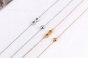 Detail shot of gold and silver infinity symbol chain necklaces with bead charms
