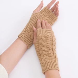 Close-up of thick cable-knit texture on camel fingerless wool gloves for winter