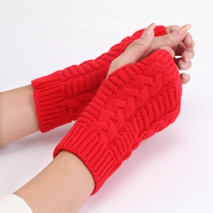 Detailed close-up of red cable knit fingerless gloves showing soft wool texture