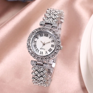 Close-up of luxury silver rhinestone watch on pink silk background with Roman numerals