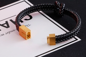 Close-up of double-layered braided black leather bracelet with gold stainless steel clasp