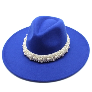 Detail of royal blue wool fedora hat featuring an elegant pearl-embellished band decoration