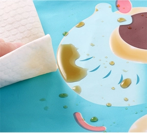 Close-up of waterproof placemat showing easy cleaning of liquid drops with a paper towel