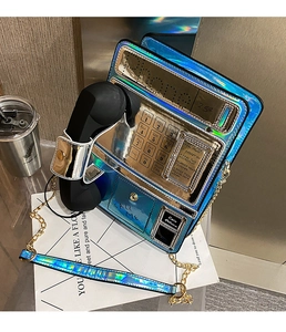 Macro shot of retro telephone-shaped crossbody bag with iridescent blue finish and chain