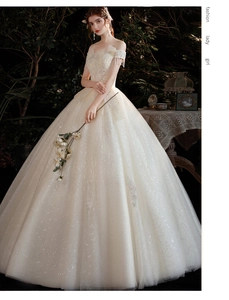 Détail de robe de mariée champagne avec broderie de feuilles à paillettes et franges