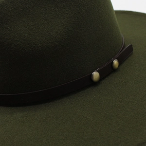 Detail of dark green wool felt jazz hat with leather band and metal buckle accents
