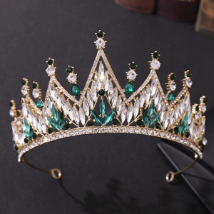Detail of golden tiara featuring sparkling emerald green and clear crystal stones