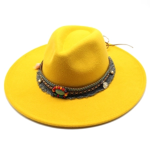 Detail of yellow wool fedora featuring ethnic woven band, turquoise bead and coin charm