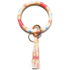 Macro detail of tie-dye pattern leather bangle keychain with long fringe and gold hardware