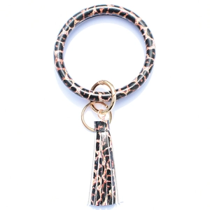 Detail of leopard print leather O-ring bracelet with golden clip and tassel pendant