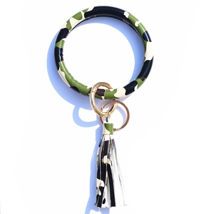 Detail showing camouflage pattern leather O-ring bracelet with tassel and gold metal clasp
