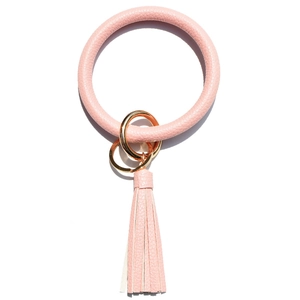 Close-up of pink lychee leather keychain bracelet with gold metal rings and tassel