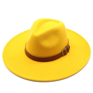 Detail of yellow wool fedora hat featuring a brown leather band and metal buckle accent