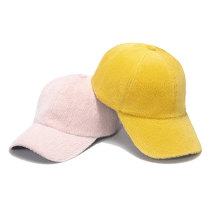 Detailed close-up showing soft faux mink fur texture in pink and yellow winter baseball caps