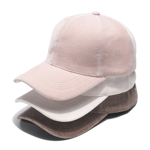 Close-up of stacked winter baseball caps in pink beige and brown corduroy texture