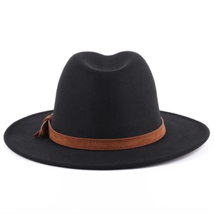 Detailed macro view of black wool fedora hat with brown suede band and side knot detail