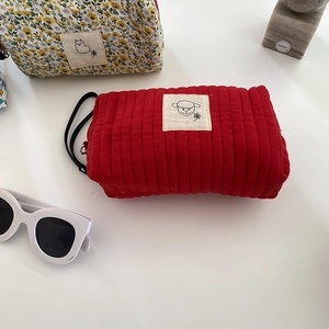 Vista dettagliata di un beauty case trapuntato rosso a fiori con etichetta e manico chic