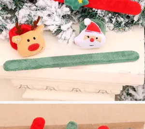 Dettaglio di braccialetti natalizi in peluche con Babbo Natale su camino innevato