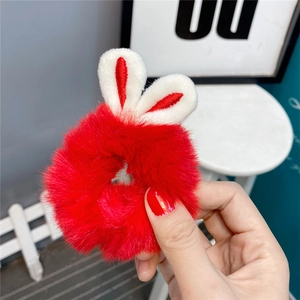 Detail of red plush hair scrunchie with cute rabbit ears and soft white embroidery