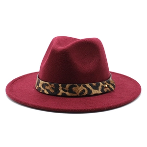 Detail of burgundy fedora hat with leopard print band and golden metal buckle