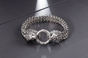 Macro detail of men's stainless steel lion head biker bracelet with heavy woven chain link