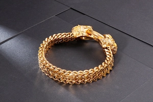 Detail of golden stainless steel double-row Cuban chain with dual lion head clasp