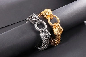 Close-up of double lion head clasp on woven steel chain bracelets in gold and silver
