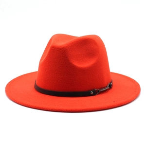 Macro detail of red wool fedora hat featuring a black leather band and metal buckle