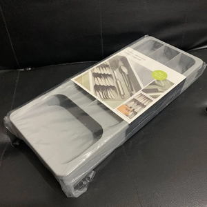 Gray cutlery and gadget organizer tray with multiple slots in English packaging