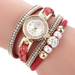 Close-up van het rode wikkelarmbandhorloge met witte strass-steentjes en parels voor dames
