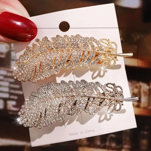 Detail shot of rhinestone feather hair clips in gold and silver showing 7cm length size