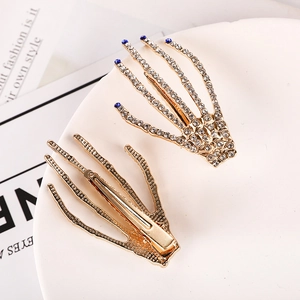 Gold skeleton hand hair clips with sparkling rhinestones and blue crystal accents