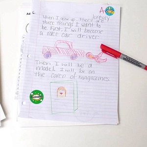 Autocollants de récompense colorés pour enseignants avec mots encourageants sur un essai