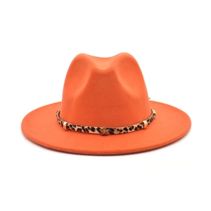 Macro shot of orange fedora wool hat with leopard print band and gold star rivet detail