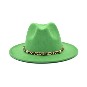 Detail of green fedora hat featuring leopard print band with gold studs and star emblem