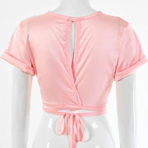 Detail view of pink satin crop top featuring open back with tie-up closure and rolled sleeves
