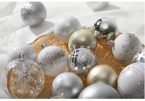 Close-up of assorted silver and champagne gold Christmas baubles on a vintage golden tray
