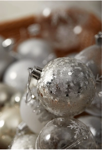 Detailed view of assorted silver Christmas ornaments with snowflake patterns and vintage finish