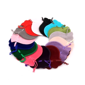 Colorful velvet drawstring jewelry pouches arranged in a circle on a white background