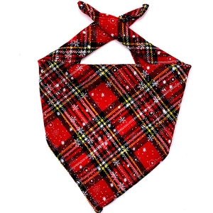 Close-up of red plaid cotton dog bandana with white snowflake prints and fabric texture