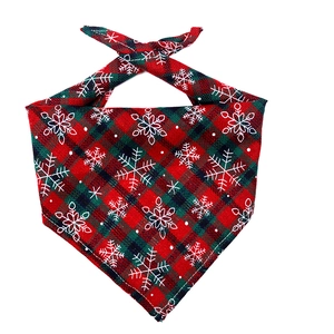 Detailed view of red and green plaid cotton Christmas dog bandana with white snowflake patterns