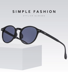 Detail of round retro sunglasses with silver rivet decor on white minimalist display