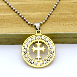 Macro shot of gold micro-pave cross pendant with sparkling crystals and silver bead chain