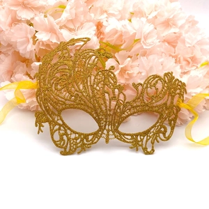 Detailed view of golden lace phoenix mask with intricate embroidery and satin ribbons
