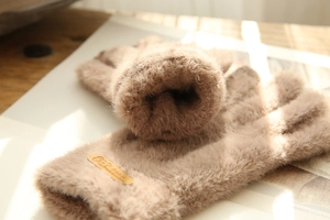 Close-up of brown plush winter gloves with soft texture and touchscreen feature