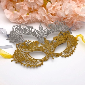 Detail of gold and silver lace masquerade masks with glitter finish and ribbon ties