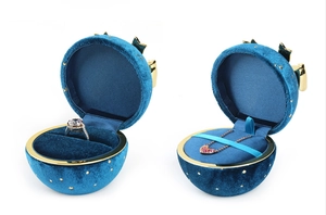 Macro detail of round blue velvet jewelry box with gold stars and ribbon decor
